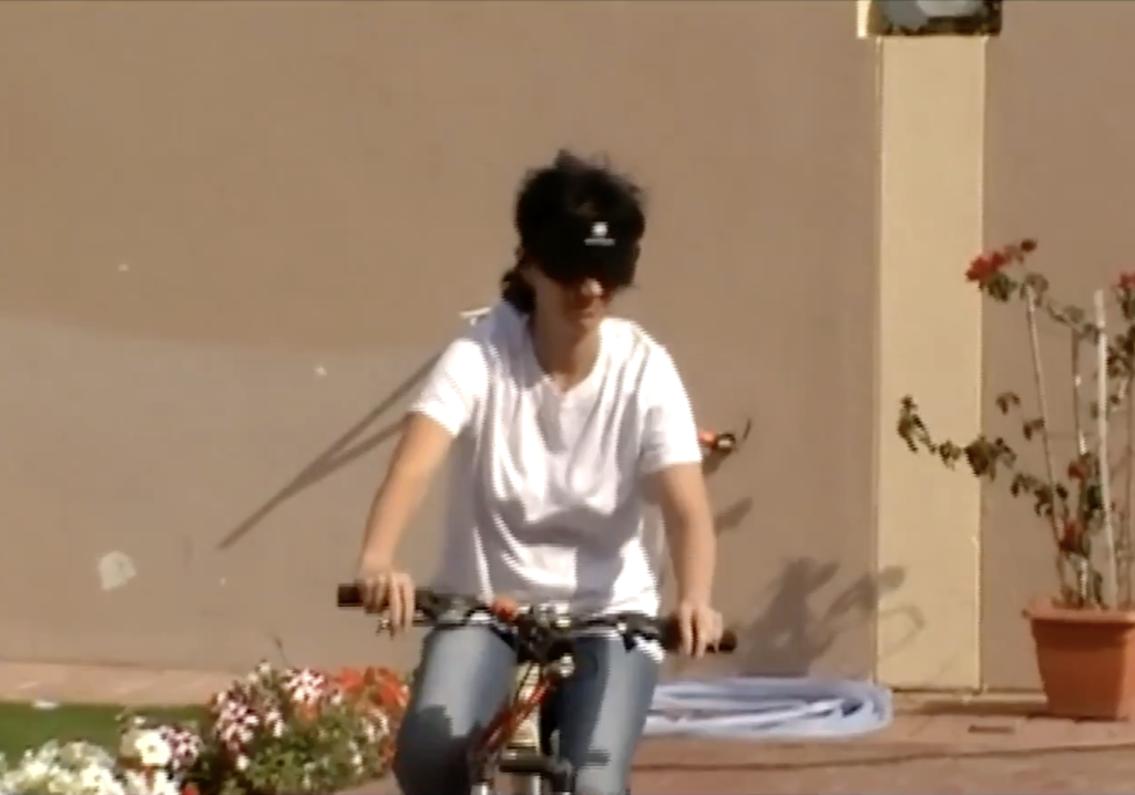 Mujer manejando bicicleta con los ojos tapados